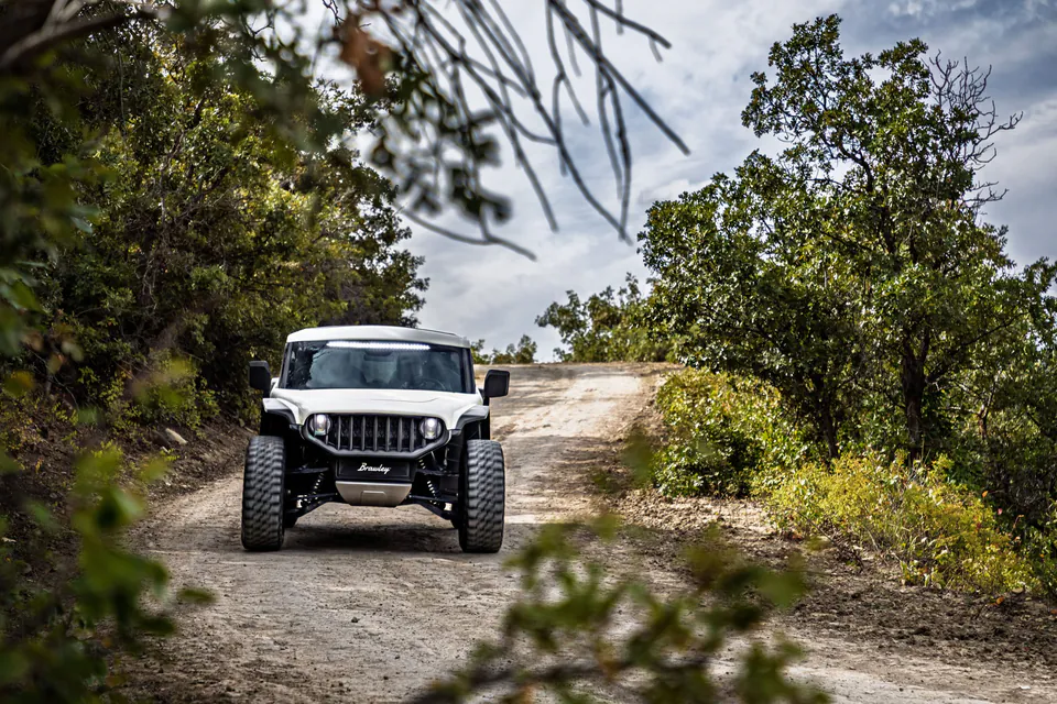 White Vanderhall Brawley climbing a gravel two-track