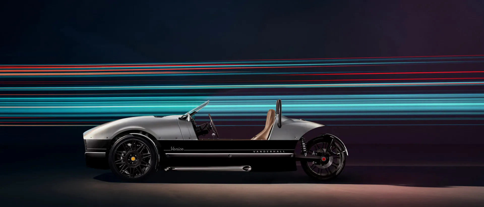 Silver Vanderhall Venice side view with motion light streaks