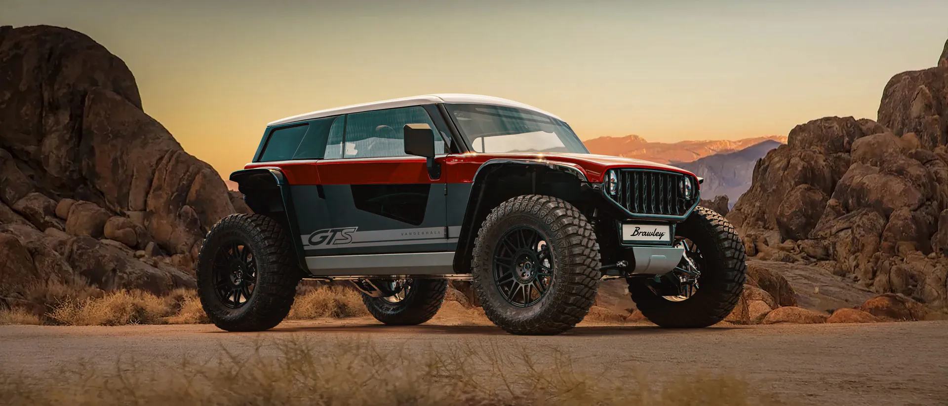 Red and white Vanderhall Brawley parked among desert rock formations